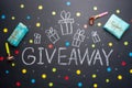 The inscription Giveaway is written on a blackboard with gifts. Free distribution, bloggers and gifts