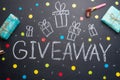 The inscription Giveaway is written on a blackboard with gifts. Free distribution, bloggers and gifts