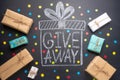 The inscription Giveaway is written on a blackboard with gifts. Free distribution, bloggers and gifts