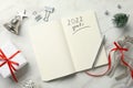 Inscription 2022 Goals written in planner and Christmas decor on white marble background, flat lay. New Year aims