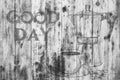 The inscription `Good day` on a gray texture of wood. Have a good day. A cup of coffee and a coffee pot.