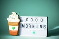 The inscription good morning on a light box with gingerbread on a mint background