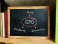 The inscription GPO Group Purchasing Organization . Blank small blackboard and different school stationery on wooden table near