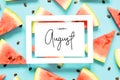 Inscription Happy August. Fresh red watermelon slice Isolated light blue background. Top view, Flat lay. Royalty Free Stock Photo