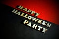 Inscription HAPPY HALLOWEEN PARTY made of wooden letters on a black-and-red background. Vignetting. Copy space. Royalty Free Stock Photo