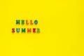 Inscription Hello Summer from colorful letters on yellow background,