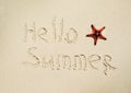 Inscription Hello Summer and starfish on the sand