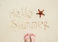 Inscription Hello Summer and starfish on the sand