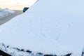 inscription on the hood of a frozen broken car covered with snow, parked outside on a frosty winter day. the engine does not star