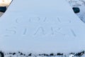 inscription on the hood of a frozen broken car covered with snow, parked outside on a frosty winter day. the engine does not star