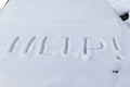 inscription on the hood of a frozen broken car covered with snow, parked outside on a frosty winter day. the engine does not star