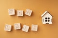 The inscription house for sale made of wooden cubes on an orange background. The concept of selling a house or apartment