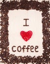 Inscription `I love coffee` made from coffee beans and red wicker rattan heart on wooden background