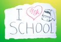 The inscription `I love school`, heart, and backpack on a piece of paper. The creative concept.