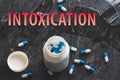 The inscription intoxication on the background of pills on a black table. Royalty Free Stock Photo
