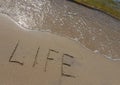 The inscription Life on the sand of the seashore. The concept of lifestyle, thirst for life, happiness, freedom Royalty Free Stock Photo