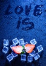 The inscription `love is` on a blue background with water drops
