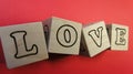 The inscription LOVE on wooden cubes. On a red background, the inscription love. Royalty Free Stock Photo