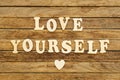 The inscription Love yourself made of wooden letters on a wooden background. Royalty Free Stock Photo