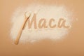 Inscription Maca of Maca gelatinized flour on beige background. Bamboo spoon with powder, top view, design element. Peruvian