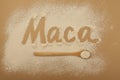 Inscription Maca of Maca gelatinized flour on beige background. Peruvian superfood, natural organic supplement. Wooden spoon with