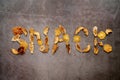 Inscription made of pieces of dried fruit in the center of a dark background. Text: Snack