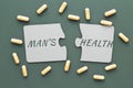 inscription male health on white disconnected puzzles, yellow pills on a green