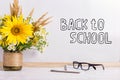 The inscription marker on a white board, Back to School. A table with a bouquet of flowers, glasses and attributes for writing Royalty Free Stock Photo