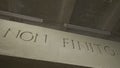 The inscription that means it is not the end on the grey wall. NON FINITO text, acronym of ancient Roman Empire