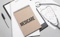 Inscription medicare. Top view of the table with stethoscope,pen and medical documents. Health care concept Royalty Free Stock Photo