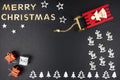 The Inscription Merry Christmas made of wooden letters, lying flat from above, isolated on a black background. Visible wooden Chri