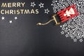 The Inscription Merry Christmas made of wooden letters, lying flat from above, isolated on a black background. Visible red sleigh Royalty Free Stock Photo