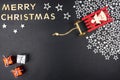 The Inscription Merry Christmas made of wooden letters, lying flat from above, isolated on a black background. Visible red sleigh Royalty Free Stock Photo