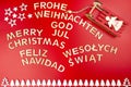 The Inscription Merry Christmas made of wooden letters, lying flat from above, isolated on a red background. Visible candy canes, Royalty Free Stock Photo