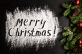 Inscription MERRY CHRISTMAS on powdered sugar background Royalty Free Stock Photo