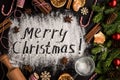 Inscription MERRY CHRISTMAS on powdered sugar background Royalty Free Stock Photo