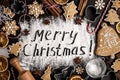 Inscription MERRY CHRISTMAS on powdered sugar background Royalty Free Stock Photo