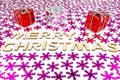 Inscription Merry Christmas on a white background with pink snowflakes and stars. Gifts wrapped in a red and silver box. Royalty Free Stock Photo