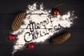 The inscription Merry Christmas , written with flour on a dark wooden background. Christmas greeting card. Royalty Free Stock Photo