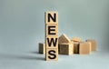 The inscription NEWS on wooden cubes isolated on a light background. The image symbolizes the beginning of the new year