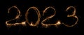 2023 inscription of numbers from sparklers and sparks on a black background. Isolated sparks of New Year's fireworks