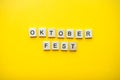 The inscription octoberfest from wooden blocks on a bright yellow background