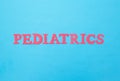 Inscription pediatrics in red letters on a blue background. Concept medical section dealing with the treatment of Royalty Free Stock Photo