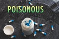 The inscription poisonous on the background of pills on a black table. Royalty Free Stock Photo