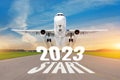 Inscription on the runway start 2023 surface of the airport road line rapidly taking off aircraft. Concept of travel in the new