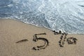 Inscription on the sand-5 % discount, sea water