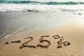 Inscription on the sand minus twenty five percent, - 25 %, the sea wave on the sand with the inscription minus twenty five