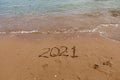 inscription on the sand 2021. symbol 2021 on the coast, overlooking the sea. Summer holidays in the new season. Royalty Free Stock Photo