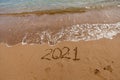 inscription on the sand 2021. symbol 2021 on the coast, overlooking the sea. Summer holidays in the new season. Royalty Free Stock Photo