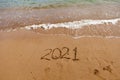 inscription on the sand 2021. symbol 2021 on the coast, overlooking the sea. Summer holidays in the new season. Royalty Free Stock Photo